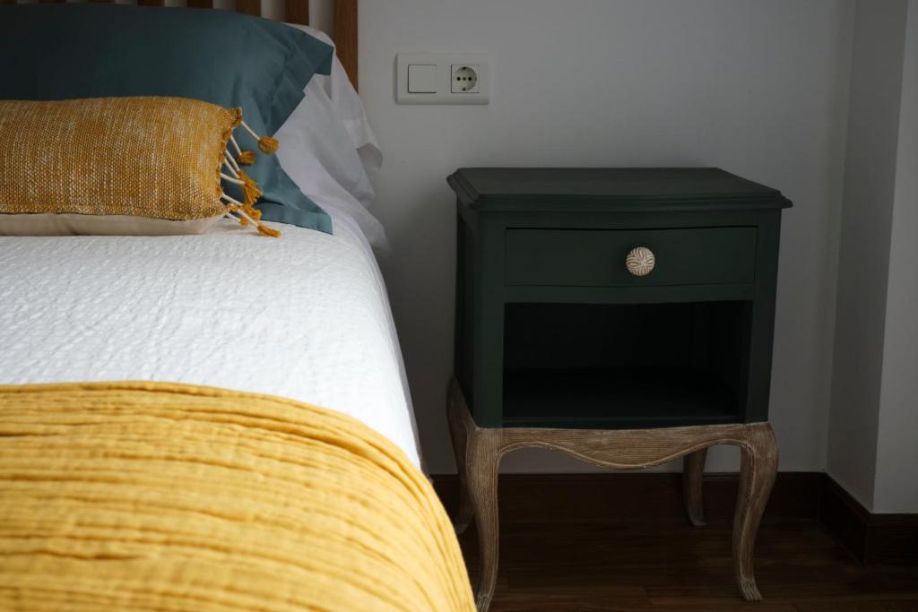 1 cama con mesita de noche verde junto a una cama con almohada amarilla en Apartamento Cabanilles, en Villaviciosa