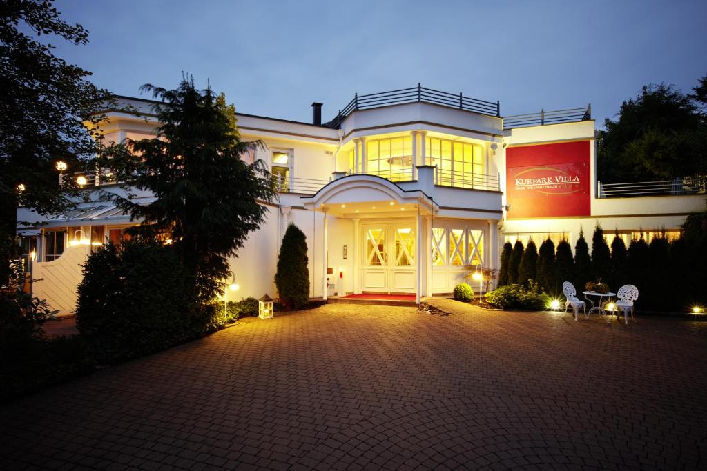 ein großes weißes Haus in der Nacht mit Auffahrt in der Unterkunft ASLAN Kurpark Villa Olsberg in Olsberg