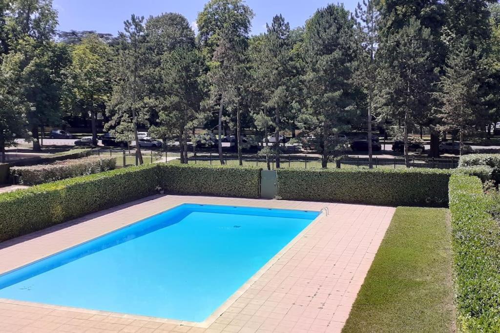 una gran piscina azul en un parque en Allées historiques du Parc de la Colombière, appt haut de gamme en Dijon