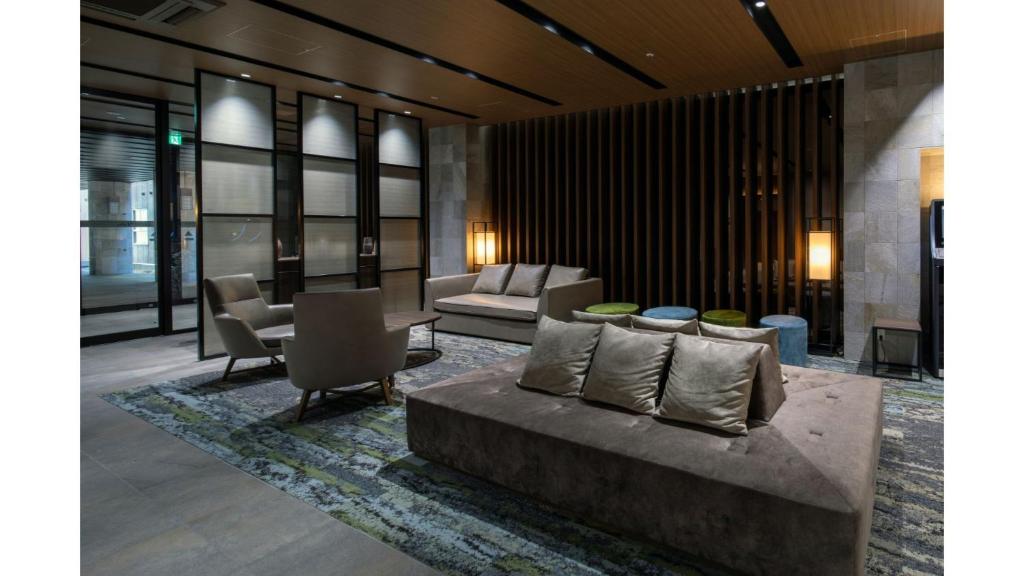 a living room with a couch and some chairs at Iroha Grand Hotel Kintetsu Nara Ekimae in Nara