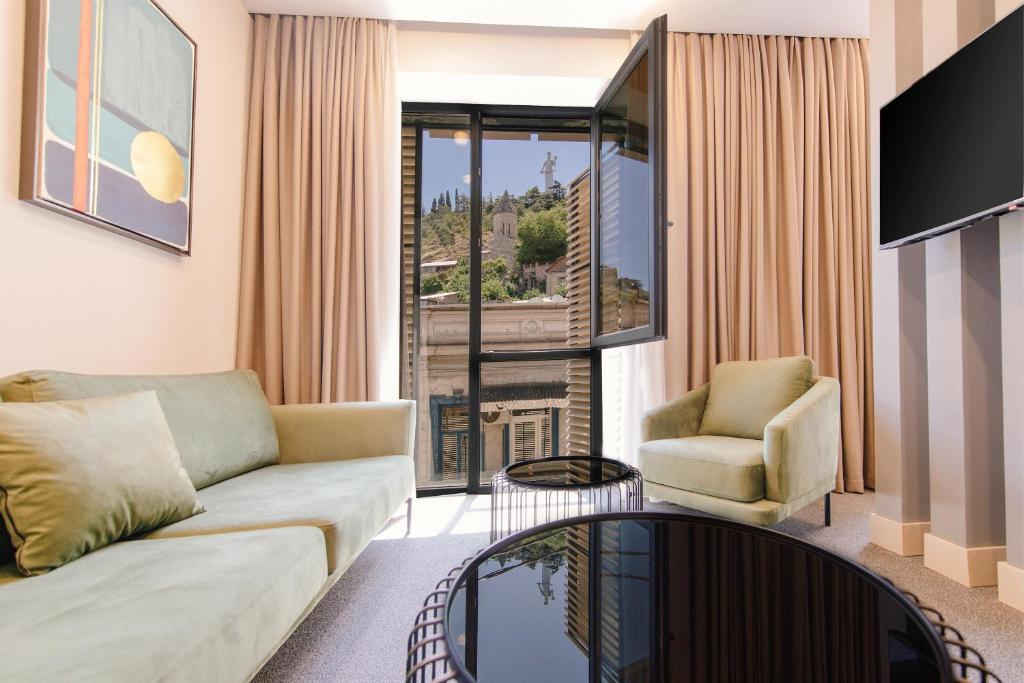 a living room with a couch and a chair at STROFI Boutique Hotel in Tbilisi City