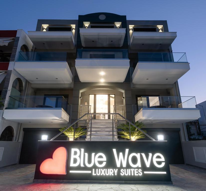un edificio con una señal de suites de lujo de onda azul delante en Blue Wave Luxury Suites, en Nea Iraklitsa
