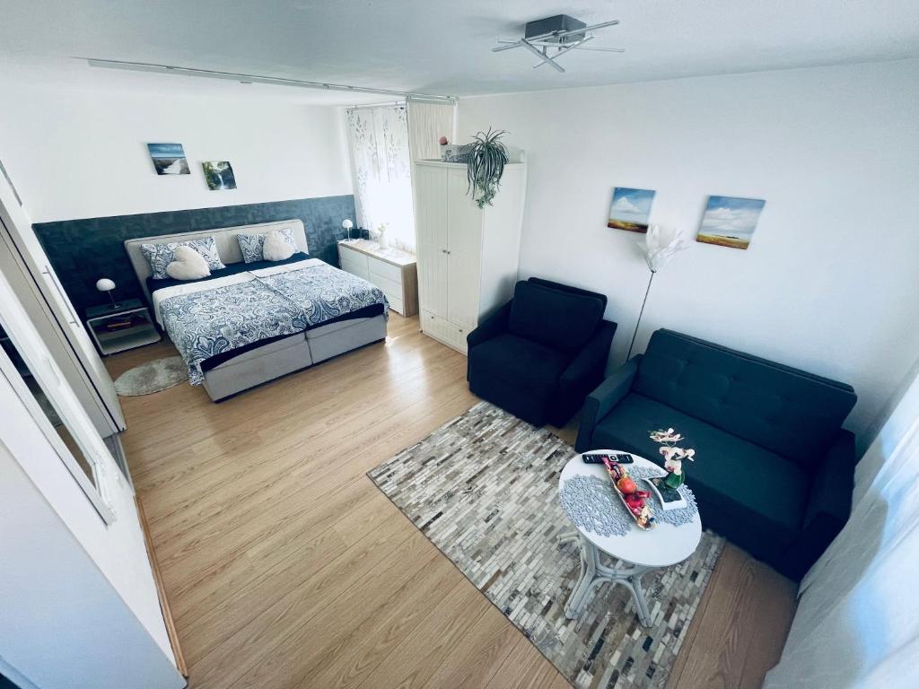 ein Wohnzimmer mit einem Bett, einem Sofa und einem Tisch in der Unterkunft Apartment Messe Karlsruhe in Rheinstetten