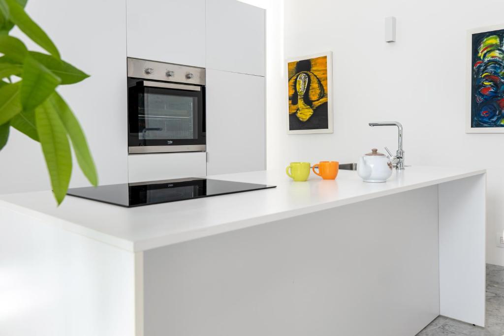 een witte keuken met een aanrecht met een magnetron bij Suite Bellini 5 Apartment in Palermo
