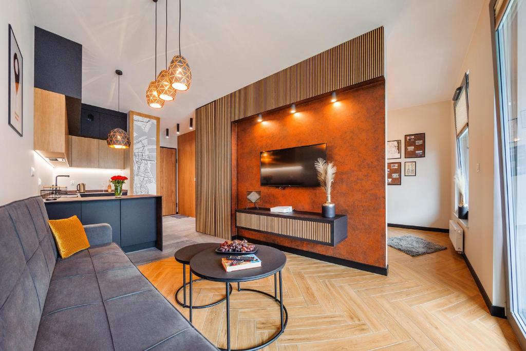 a living room with a couch and a table at Plac Unii - Premium Apartments in Gdynia