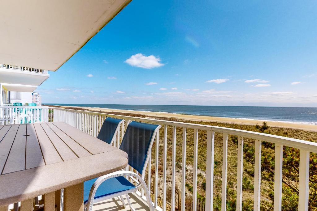 a balcony with a table and chairs and the beach at Adagio 303 in Ocean City