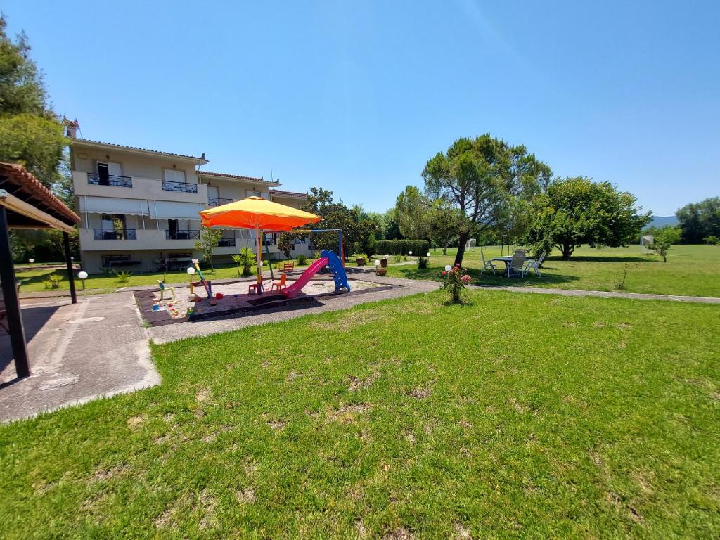 オレオイにあるElia Apartmentsのオレンジの傘とピクニックテーブルのある公園
