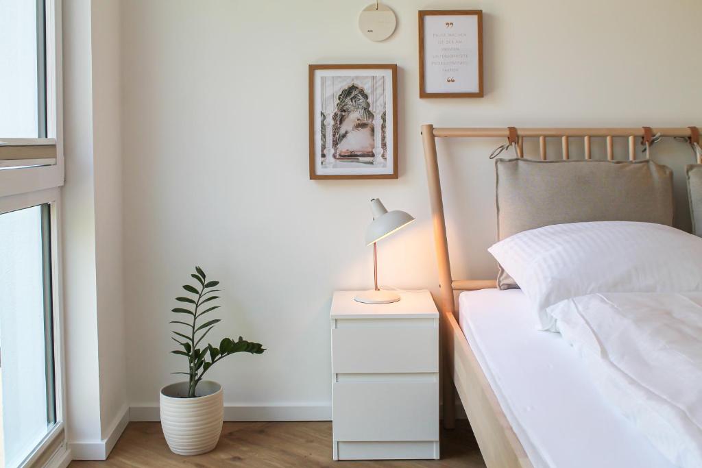 a bedroom with a bed with a lamp and a plant at Relax Apartment - für Familien, stadtnah, mit Parkplatz in Koblenz