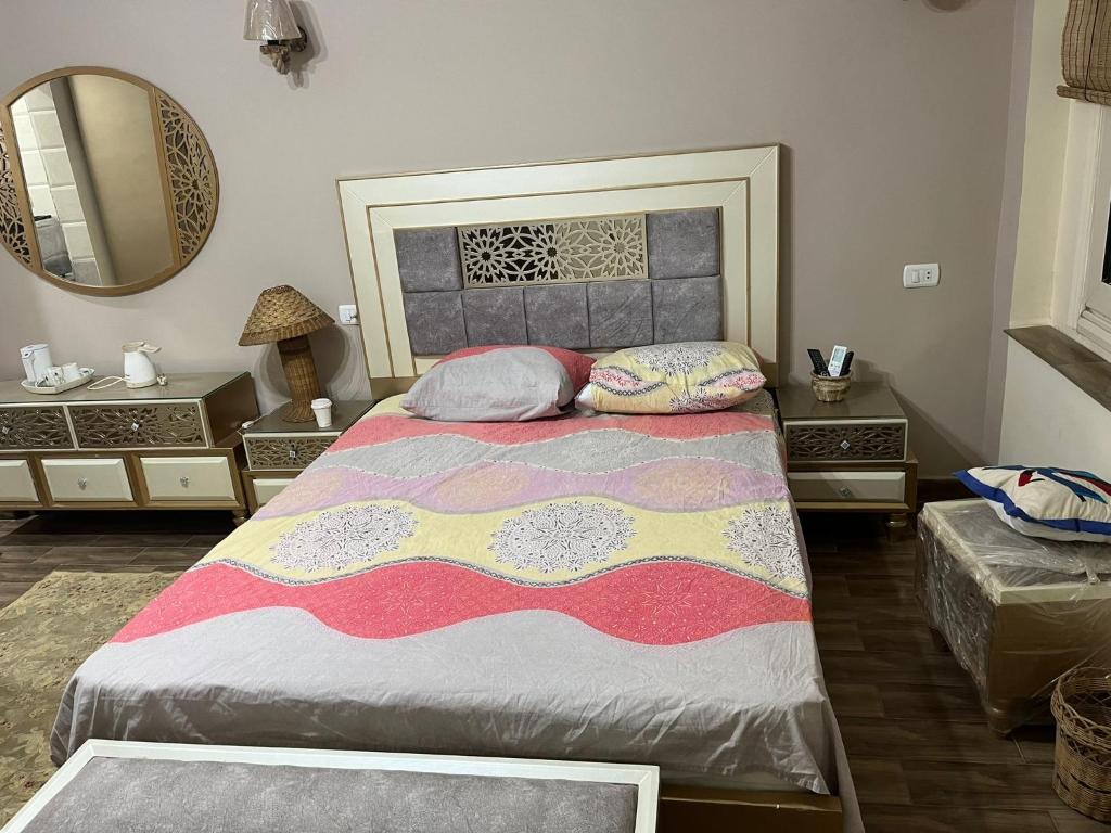 een slaapkamer met een groot bed en een spiegel bij Fifth Settlement Apartment in Caïro