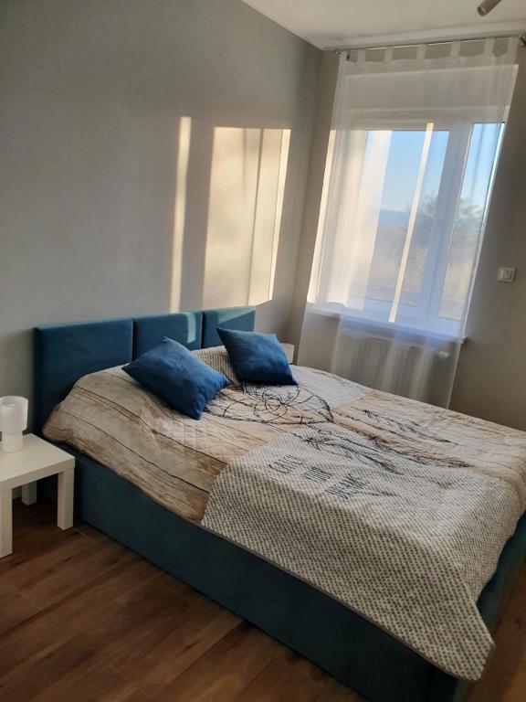 Apartament na Letniej في كوادسكوم: غرفة نوم عليها سرير ومخدات زرقاء