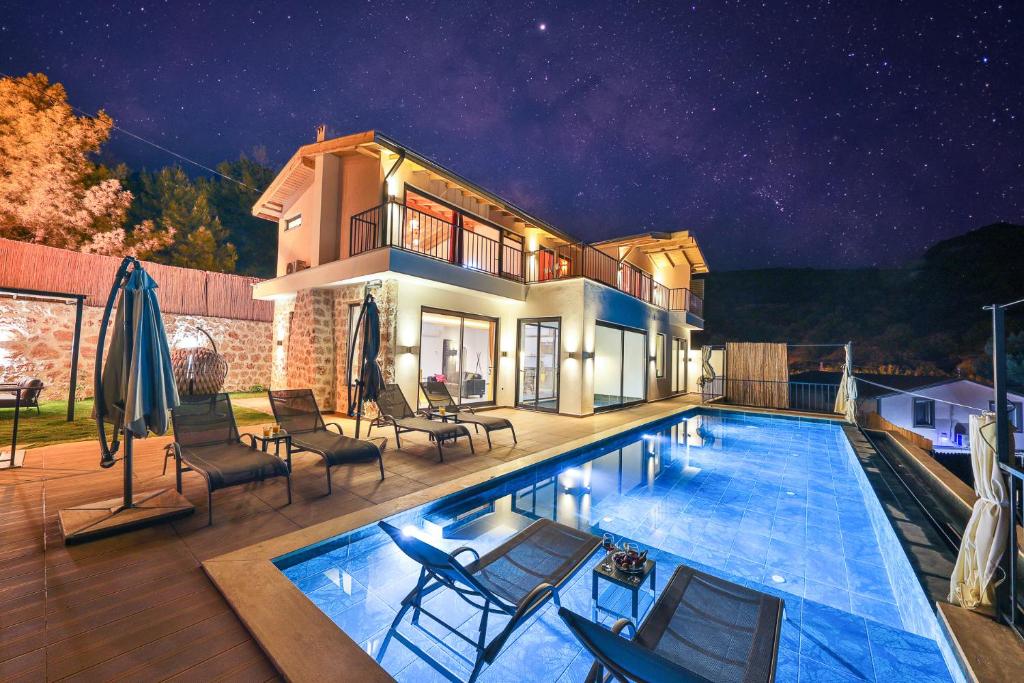 a house with a swimming pool at night at Villa mirador in Kas