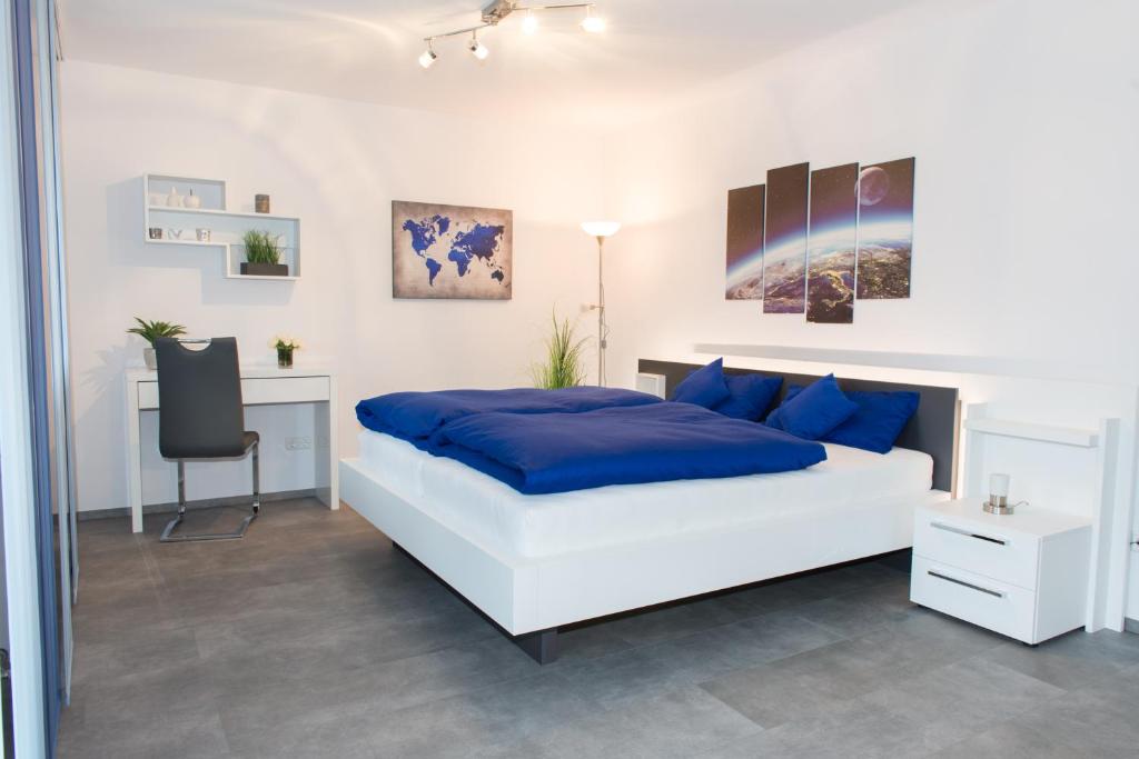 a bedroom with a bed with blue pillows and a desk at WiLoMa in Baden-Baden