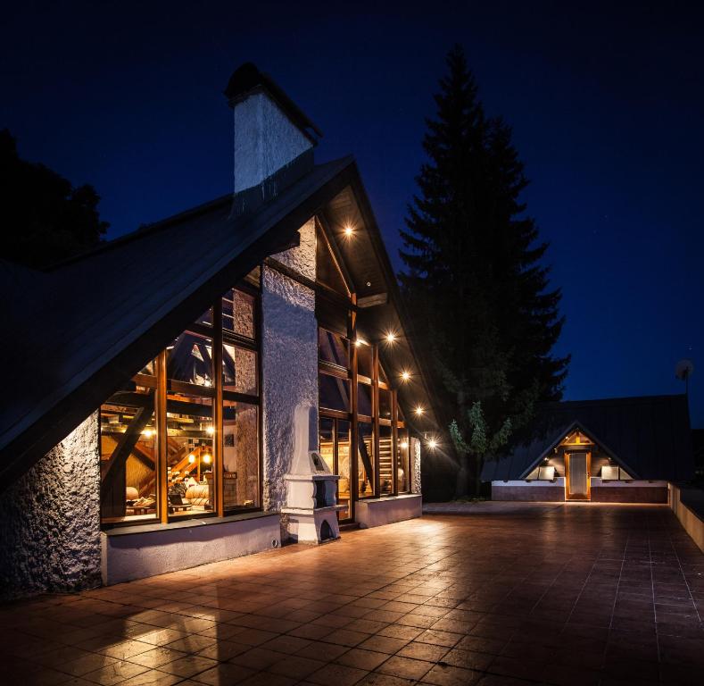 un bâtiment éclairé la nuit avec des lumières dans l'établissement Chalet Drevarska, à Benecko