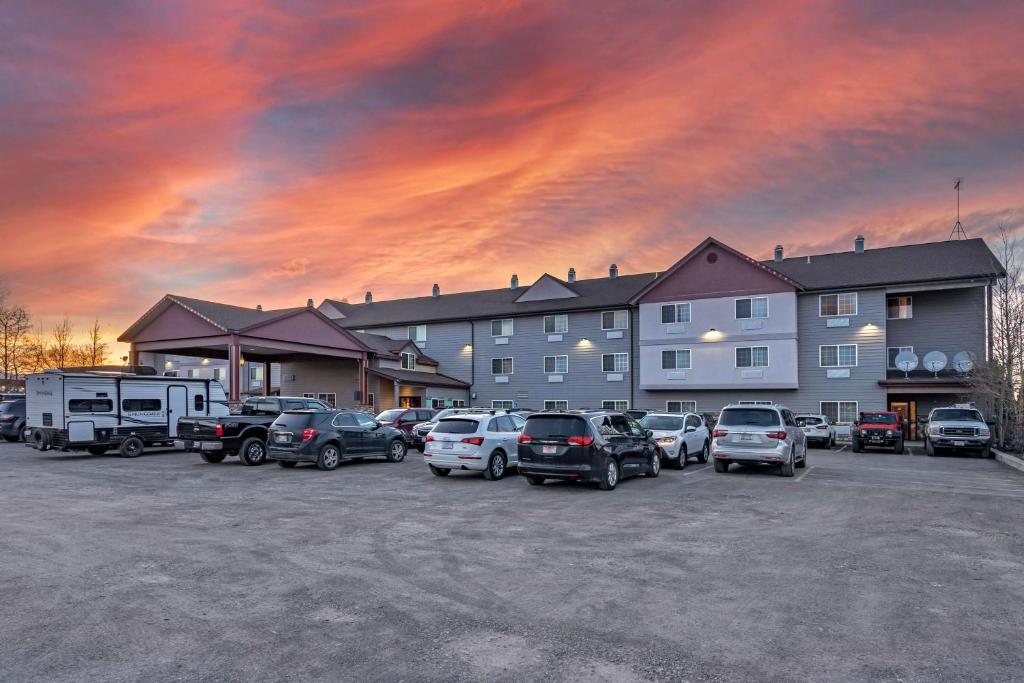a parking lot with cars parked in front of a hotel at Best Western Desert Inn in West Yellowstone