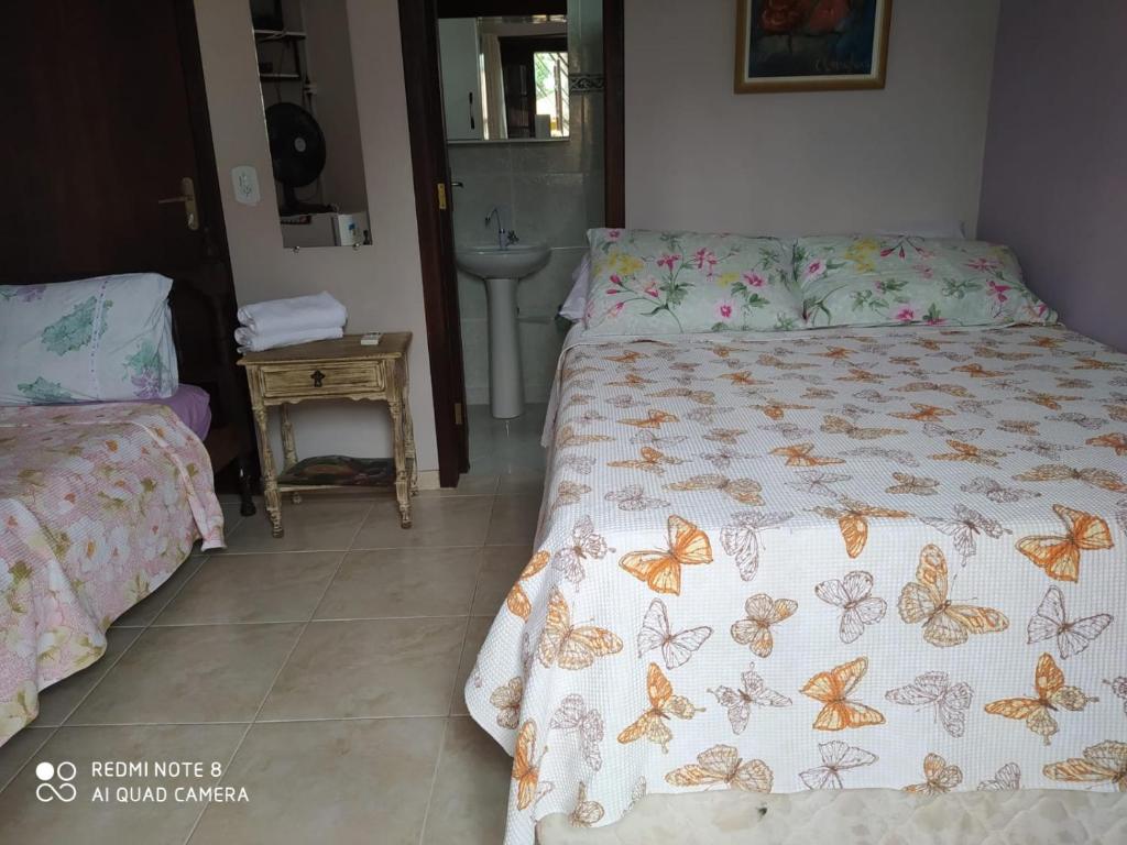 een slaapkamer met 2 bedden en vlinders op de lakens bij RESIDENCIAL CANTINHO PANTANEIRO in Itapoa