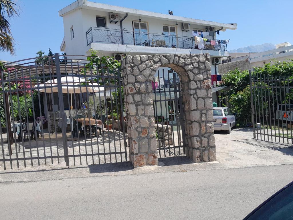 a gate with a stone arch in front of a building at Apartments Kalamperovic in Bar