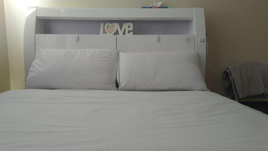 a large white bed with white sheets and pillows at 119 the shaftesbury in Barking