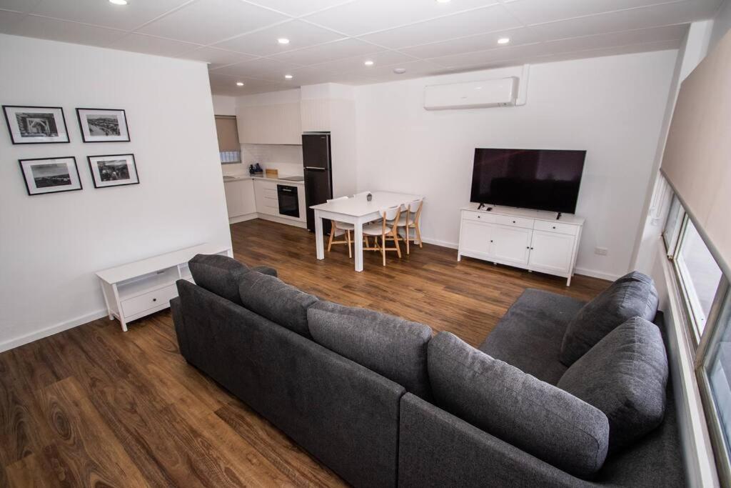 un soggiorno con divano, TV e tavolo di Willow Court Unit 2 a Broken Hill