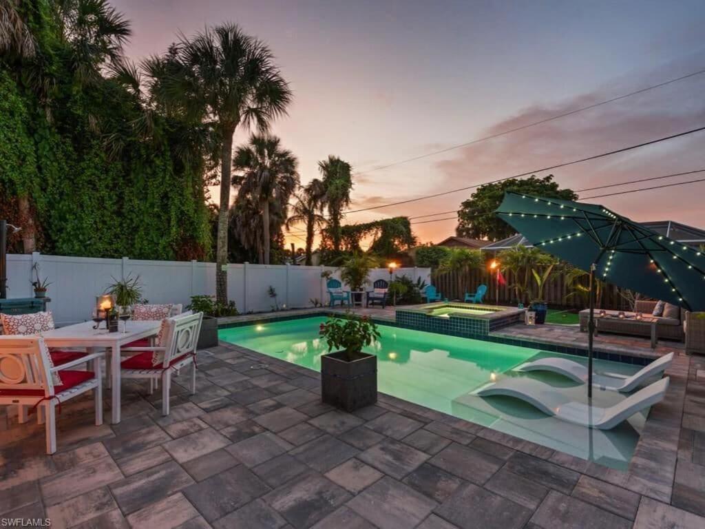 a backyard with a swimming pool with a table and chairs at Sanctuary Home Naples-Private Pool and Lanai! in Naples