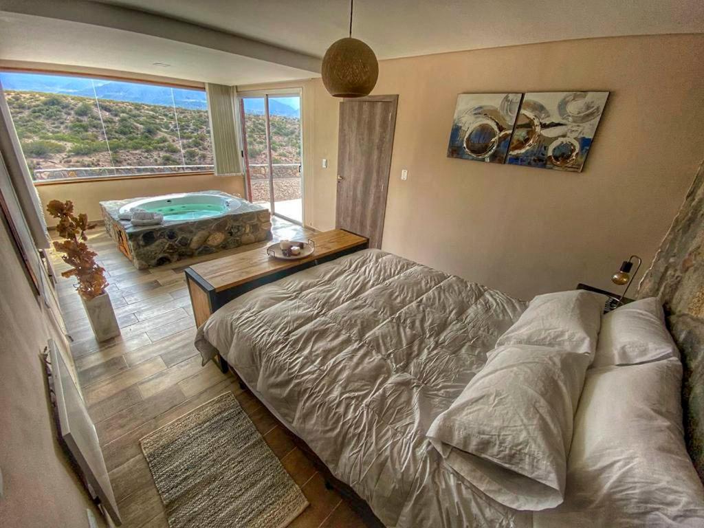 1 dormitorio con cama y vistas a la piscina en Potre casas de montaña en Potrerillos