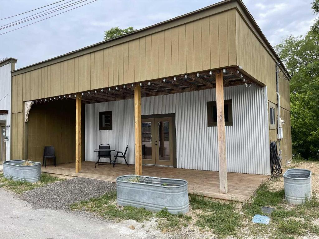 a large building with a porch and two buckets at Trails End Retreat in Bandera