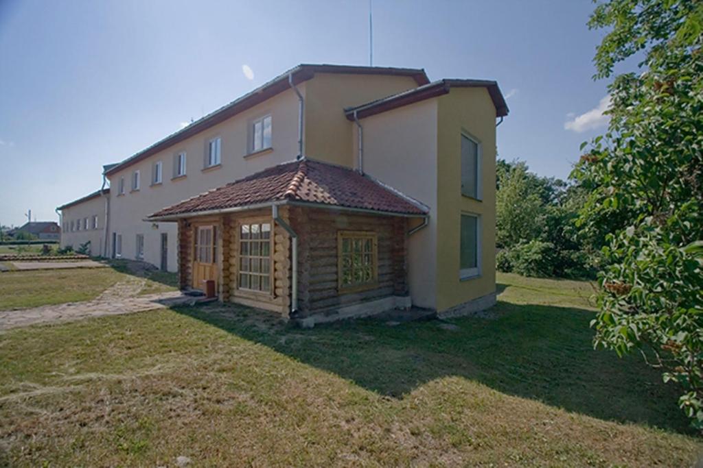 a large building with a yard in front of it at Motelis Aldari in Pastende