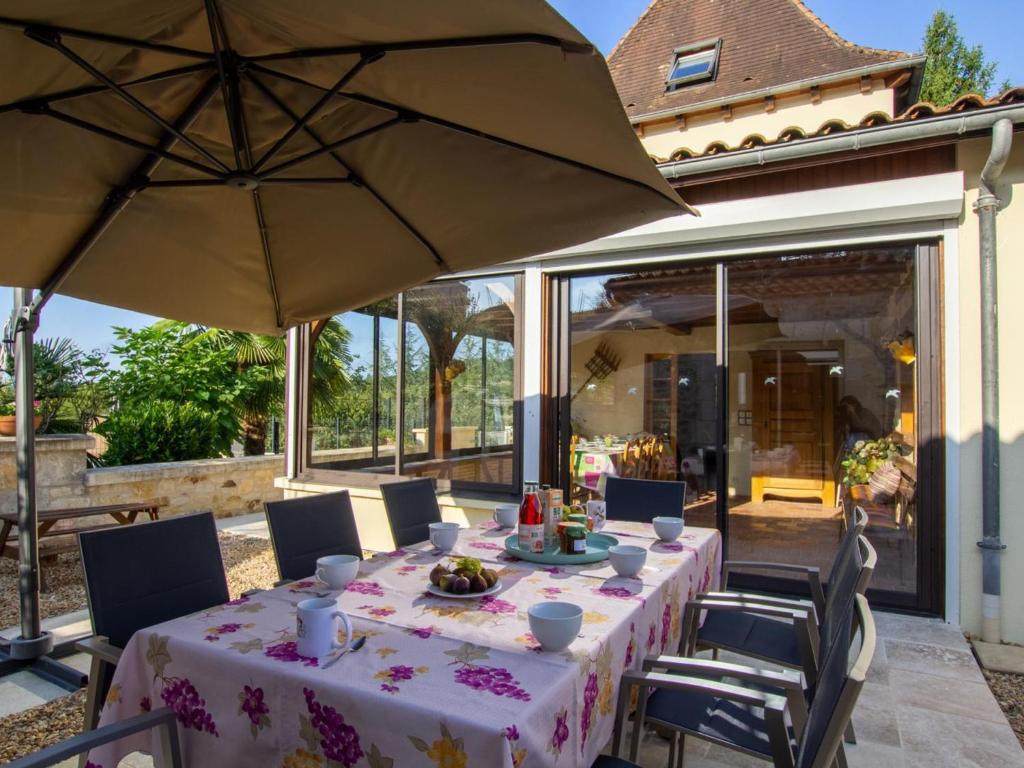 a table with an umbrella on a patio at Maison de charme avec piscine privée, salle de sport proche de Bergerac et Périgueux - FR-1-616-132 in Villamblard