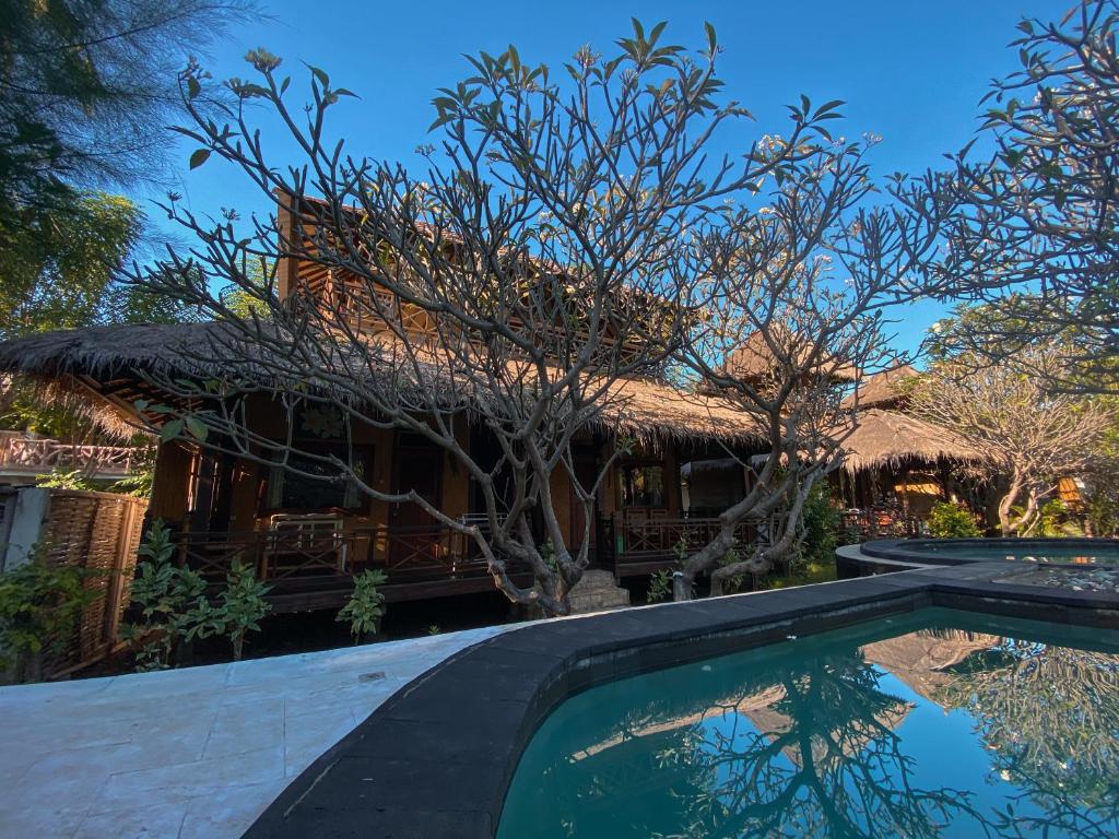 una casa con piscina di fronte a una casa di Sejuk Cottages a Gili Air