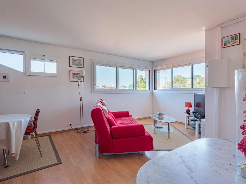 een woonkamer met een rode stoel en een tafel bij Appartement Saint-Jean-de-Luz, 1 pièce, 4 personnes - FR-1-4-638 in Saint-Jean-de-Luz