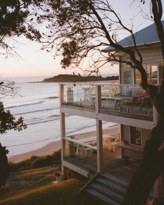 a house on the beach next to the ocean at Bay Properties Beach House Upstairs in Yamba