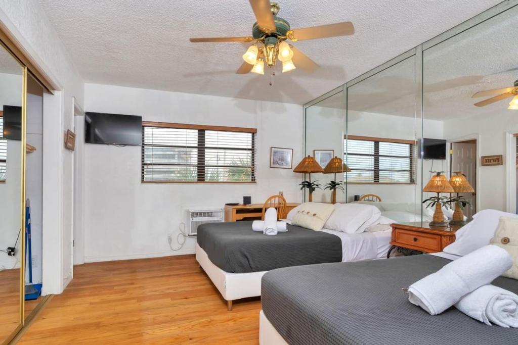 a bedroom with two beds and a ceiling fan at Hollywood Oasis: Lovely Studio with Free Parking in Hollywood