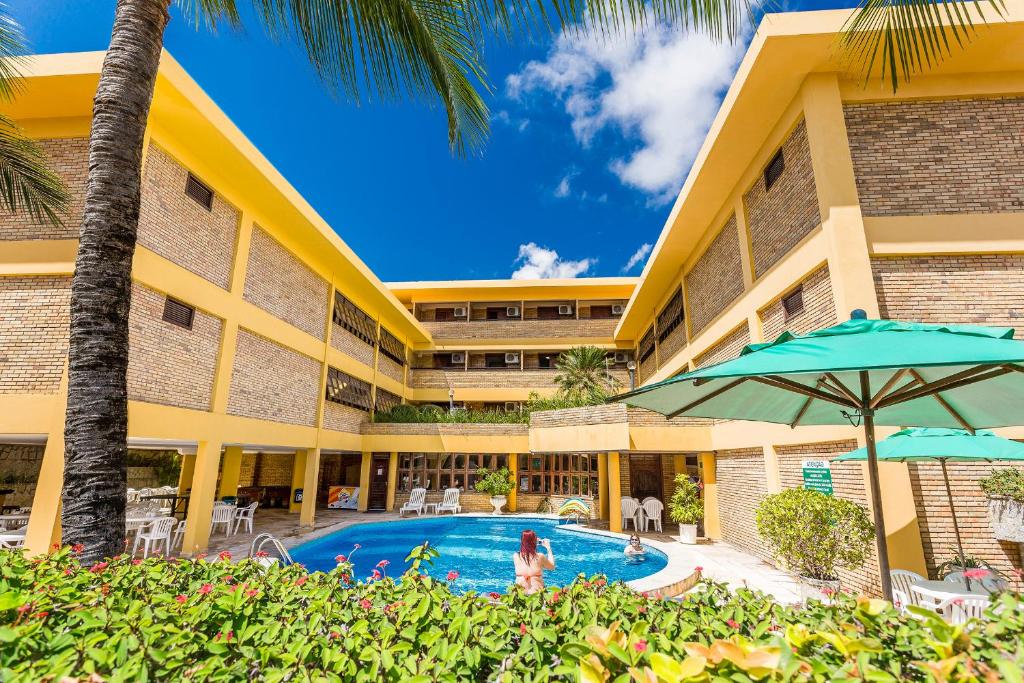 um hotel com piscina e um edifício em Pizzato Praia Hotel em Natal