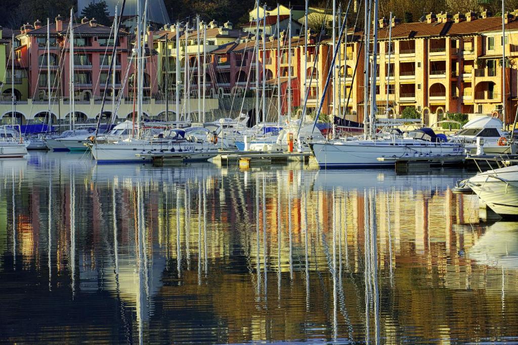 a group of boats are docked in a harbor at Hotel San Rocco in Muggia