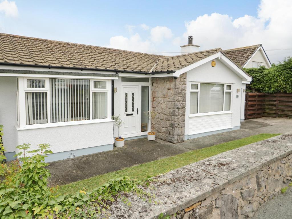 a bedroom cottage in a street with a driveway at Moranva in Benllech