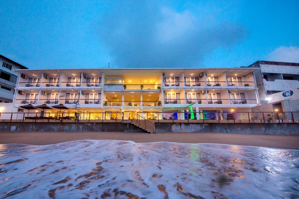 a hotel on the beach at night at Coral Rock by Bansei in Hikkaduwa