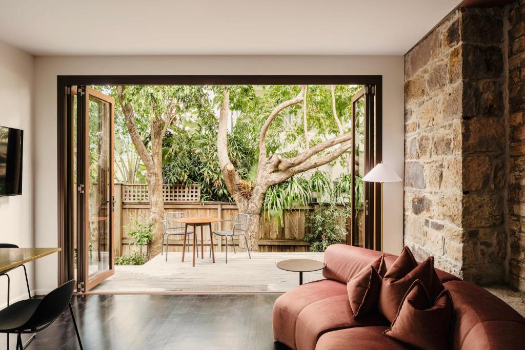 a living room with a couch and a large glass door at Miss Midgley's - Principals Office in Brisbane