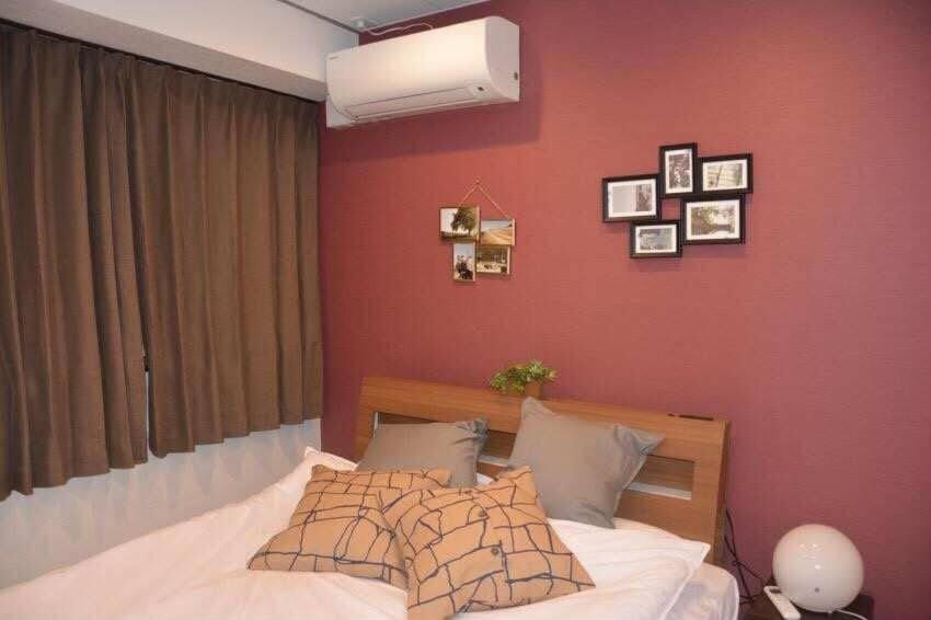 - une chambre dotée d'un lit avec un mur rouge dans l'établissement AN HOTEL, à Tokyo