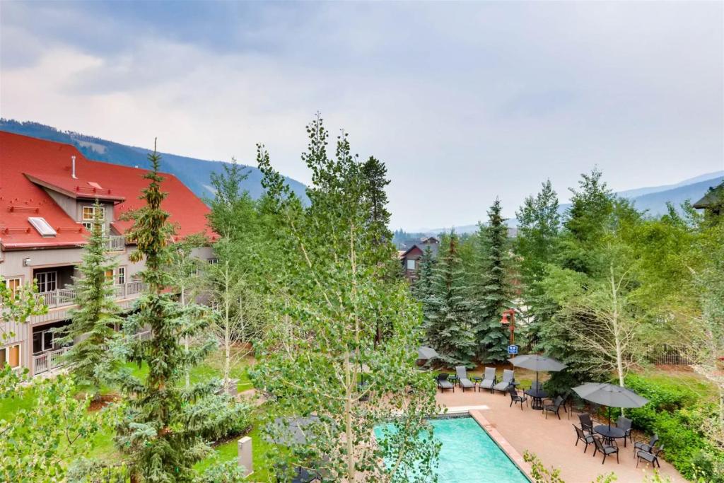 an aerial view of a resort with a swimming pool and trees at 2 Bedroom Colorado Vacation Rental In River Run Village With Pool And Hot Tub Access in Keystone