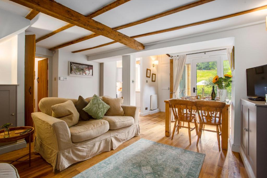 - un salon avec un canapé et une table dans l'établissement Meadow Brook Cottage, à Blockley