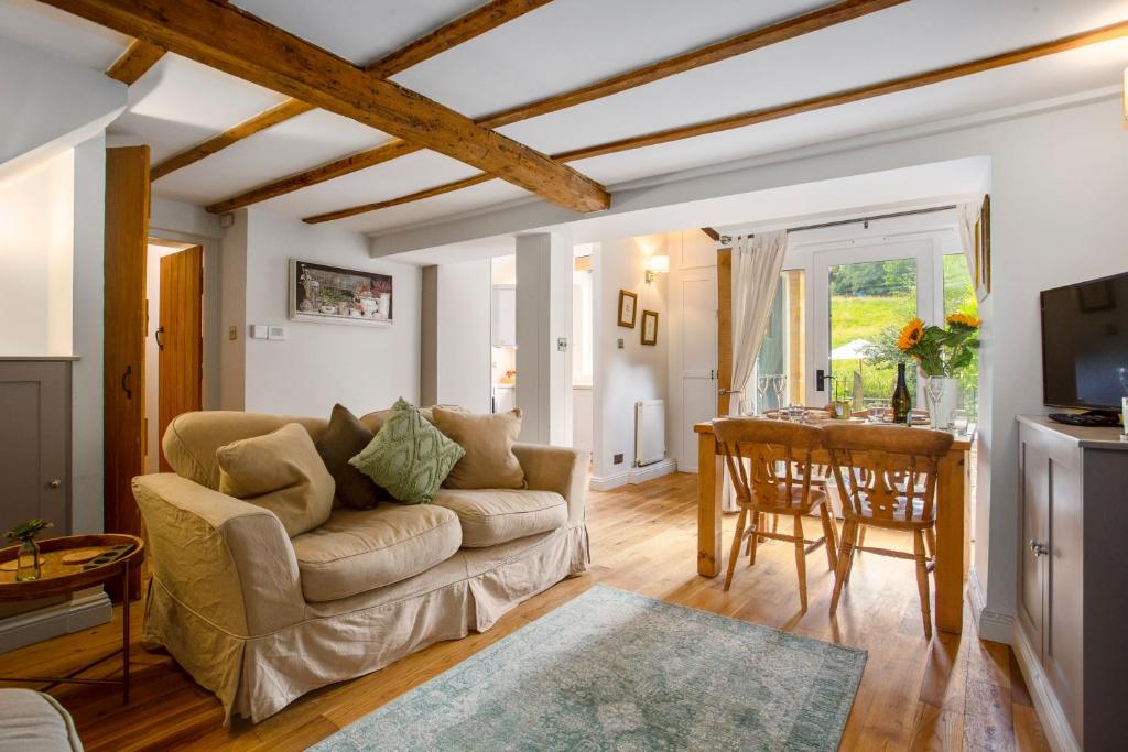 a living room with a couch and a table at Meadow Brook Cottage in Blockley