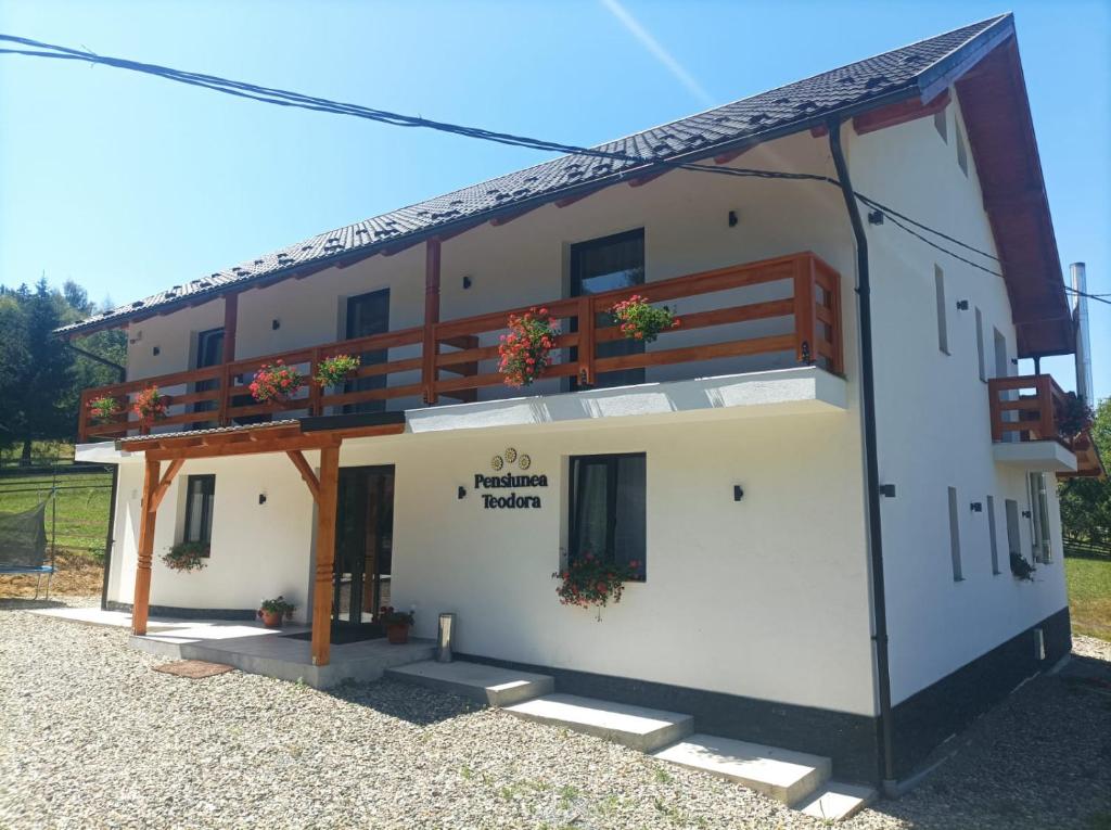 a large white building with a balcony at Pensiunea Teodora in Moisei