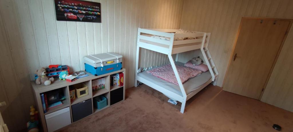 a childs bedroom with a bunk bed and a shelf at Ferienwohnung Sommerbrise in Gelbensande