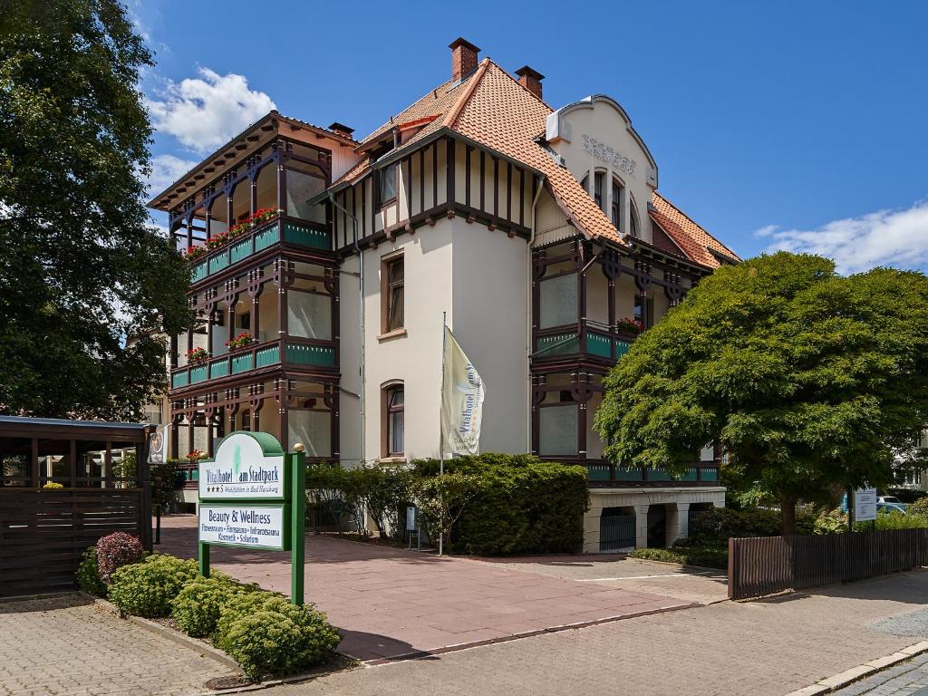 un edificio con un cartello di fronte di Vitalhotel am Stadtpark Superior a Bad Harzburg