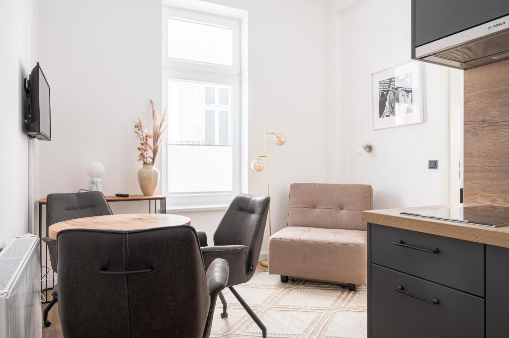- une cuisine avec une table, des chaises et un canapé dans l'établissement JOHOUSE Apartment 3, à Warnemünde