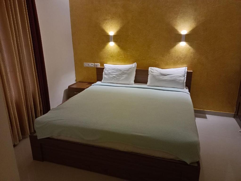 a bed in a room with two lights on the wall at COCHIN HOMES in Ernakulam