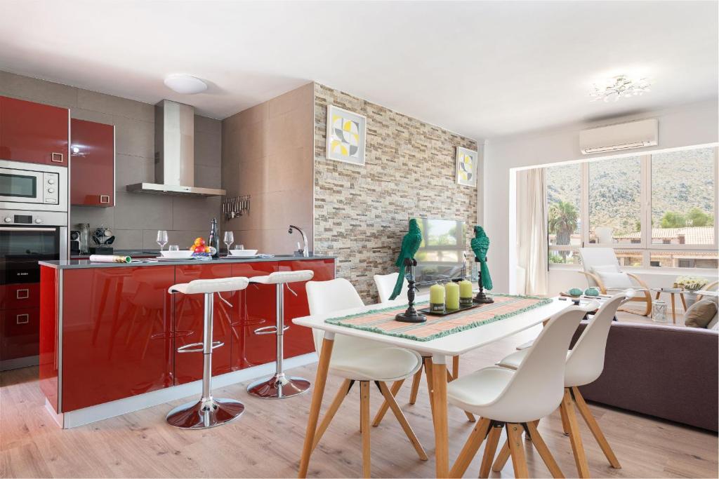 Una cocina y una sala de estar con mesa y sillas. en Apartment Scandi - Alcúdia, en Alcudia