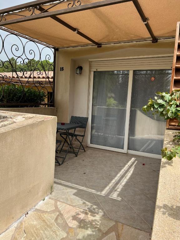 d'une terrasse avec une porte coulissante en verre et une table. dans l'établissement Les Jardins De Santa Giulia - Charmante chambre dhte, à Porto-Vecchio