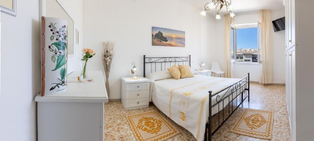 una camera bianca con un letto e una finestra di Pintadera B&B a Cagliari
