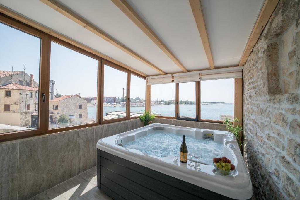 bañera en una habitación con ventanas en Luxury Villa Christian, en Umag