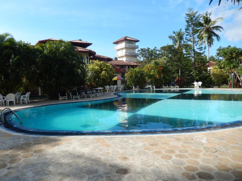 una piscina en un complejo con una torre en el fondo en Villa Ranmenika, en Ahungalla